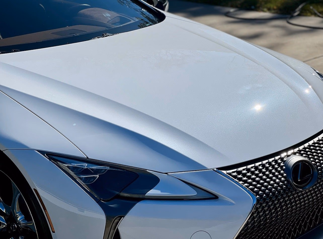 Close view of a white Lexus hood and headlight, supplied by Shine Theory